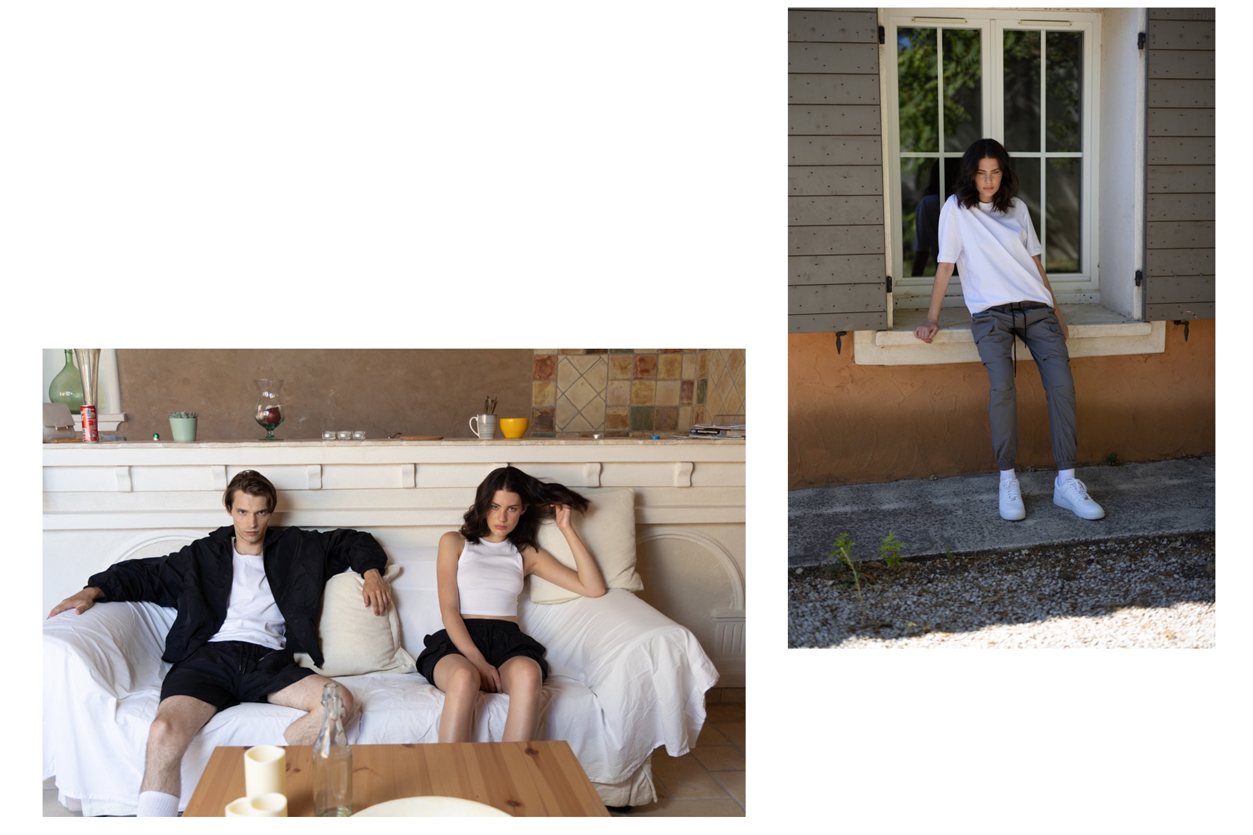 A male model wearing a black zip-up jacket and black cargo shorts is seated on a couch next to a female model wearing a white tank top and black cargo shorts.