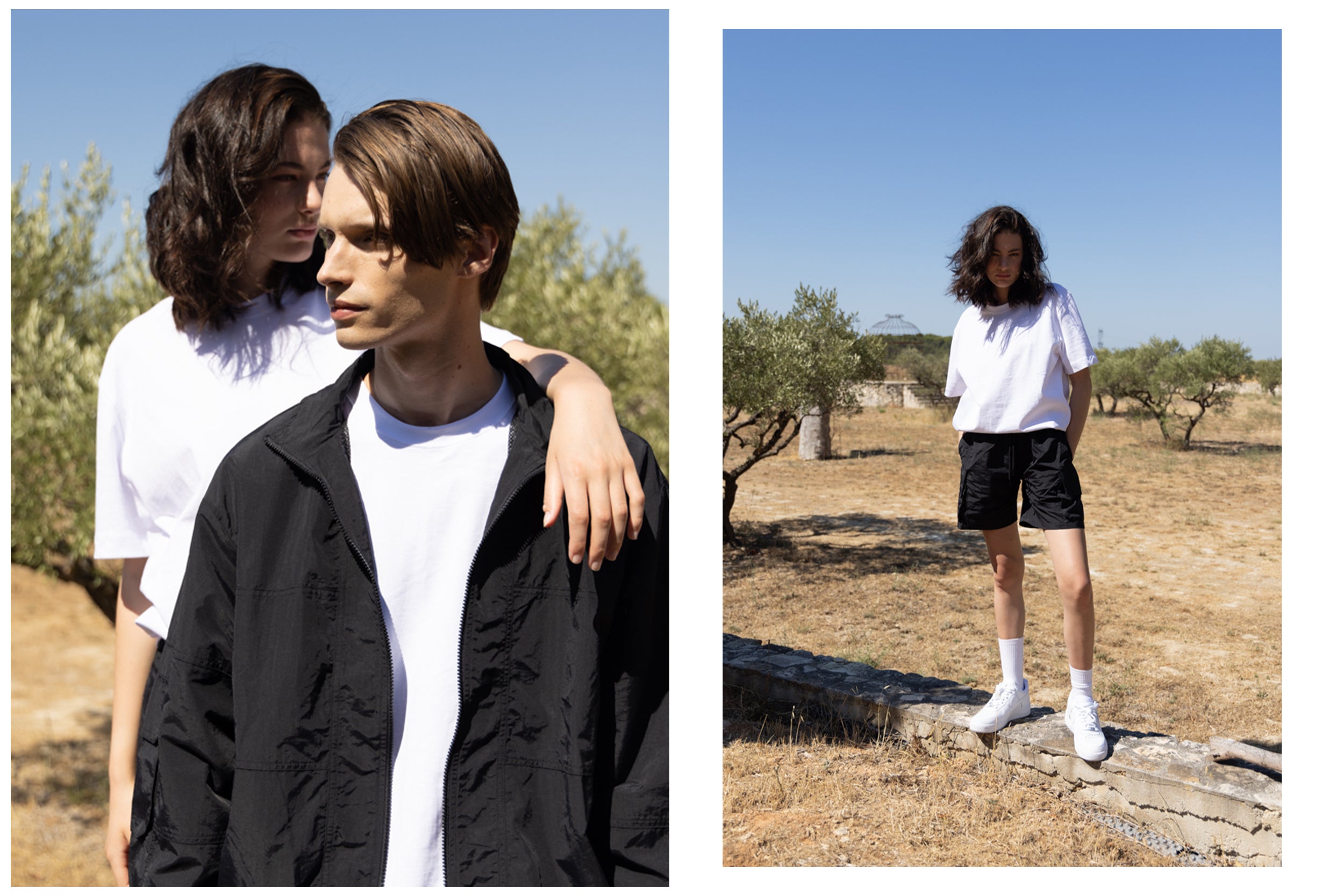 A male model wearing a black zip-up jacket and black cargo pants stands beside a female model wearing a white t-shirt and black cargo shorts, posing in a grassy field.