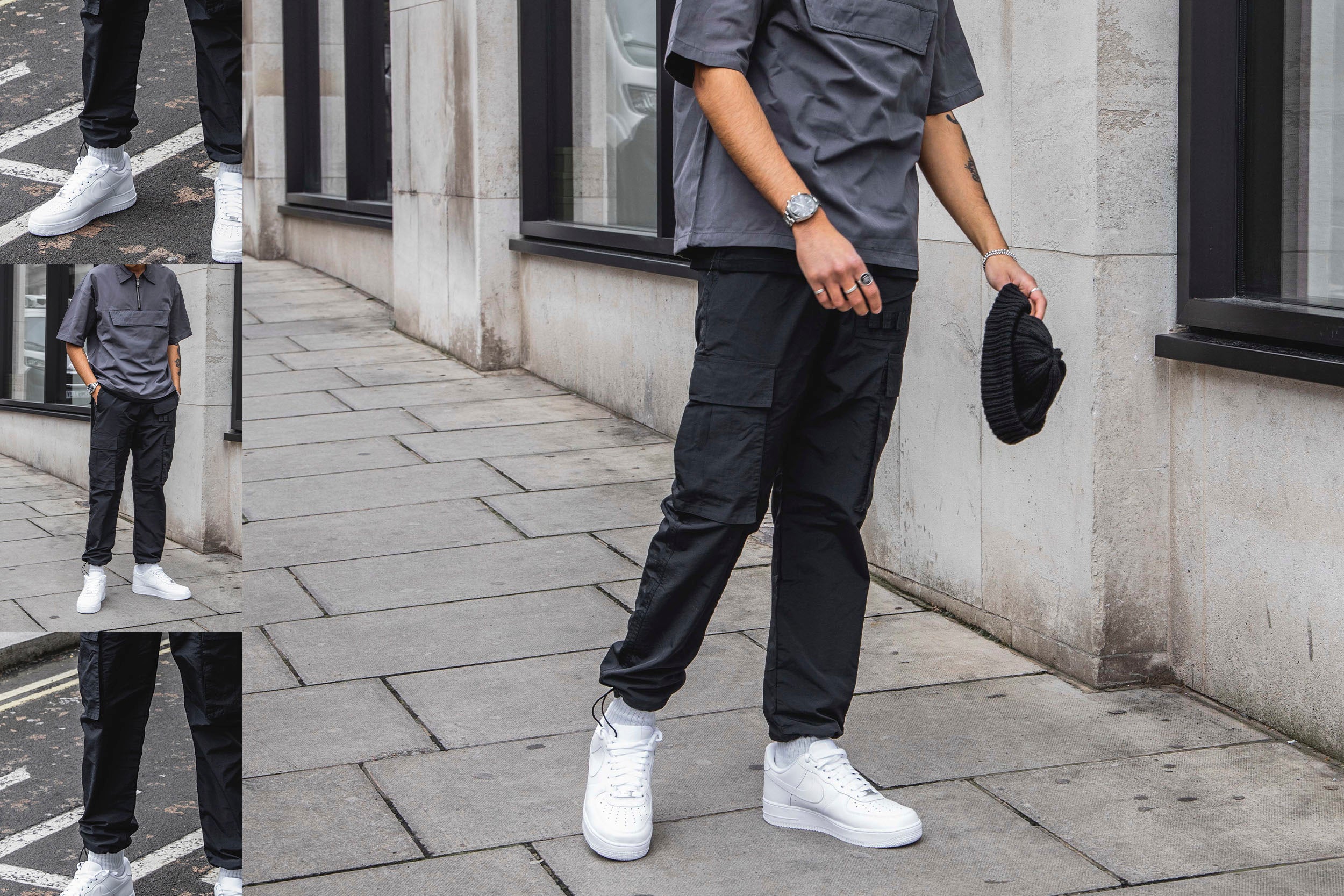A male model in grey tee and black cargo pants standing on the street.