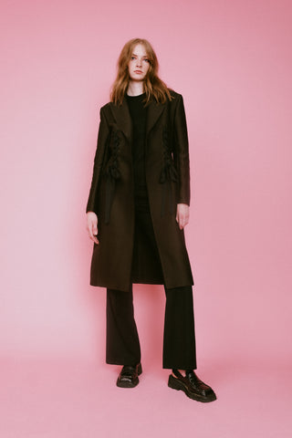 brown coat with lacing detail, black flare pants