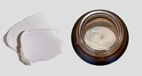 Flatlay shot of open jar of 002-Pu-Purifying Facial with texture blobs