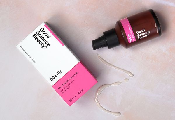 Flatlay shot of 004-Br Skin Brightening Cream bottle and box on pink marble