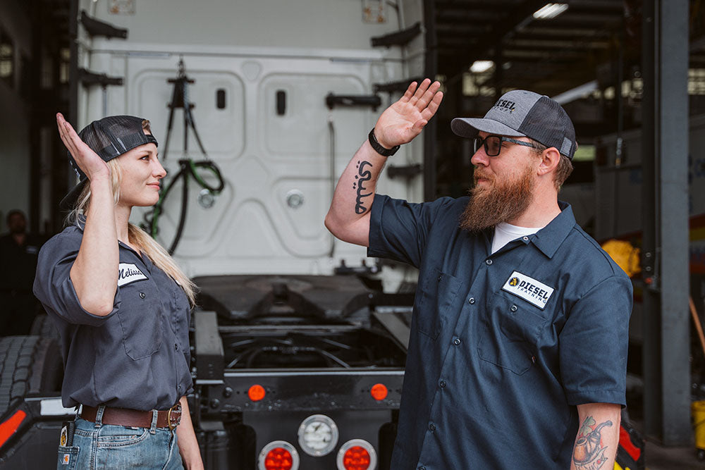 two diesel techs high fiving