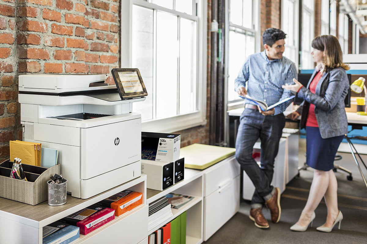 All in one printer device in an office with people in the background