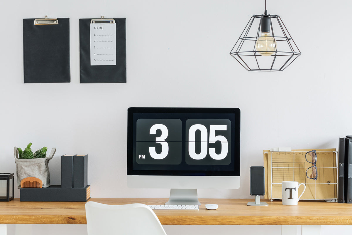 An organized office desk with the time 3:05 on computer screen