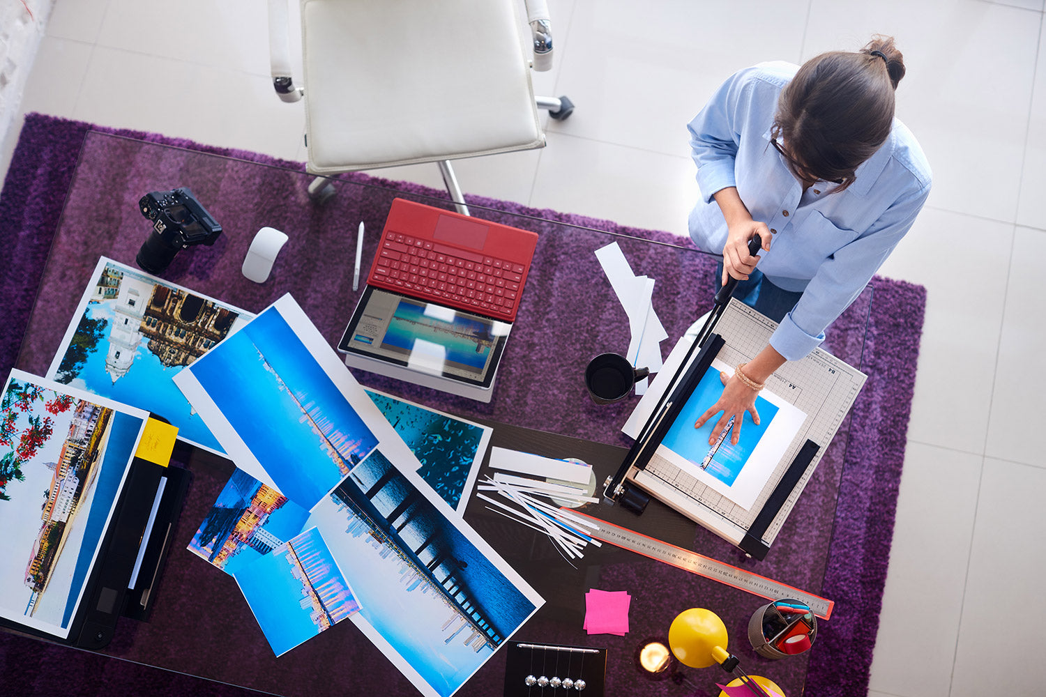 Woman sitting at desk with color prints from a Canon color printer