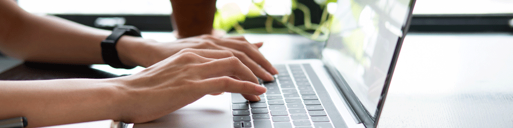 Woman working from home and typing on laptop