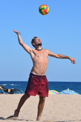 Man at the beach hitting a volleyball