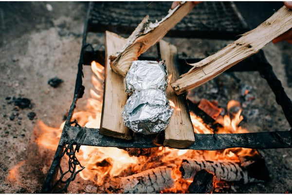 A couple of foil-wrapped packages on an open campfire, some of the easiest backcountry meal ideas