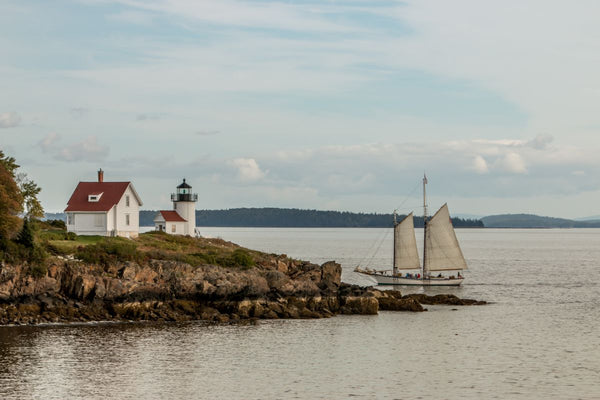 A schooner off the coast of Maine near a lighthouse
