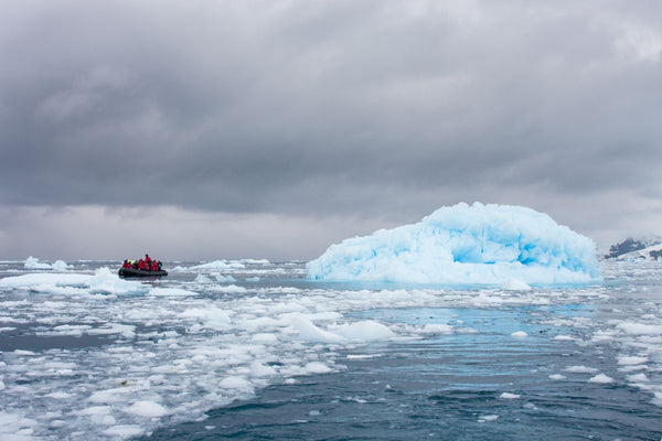 A Zodiac inflatable boat exploring icy waters in Antarctica, one of the excursion options on unique cruises