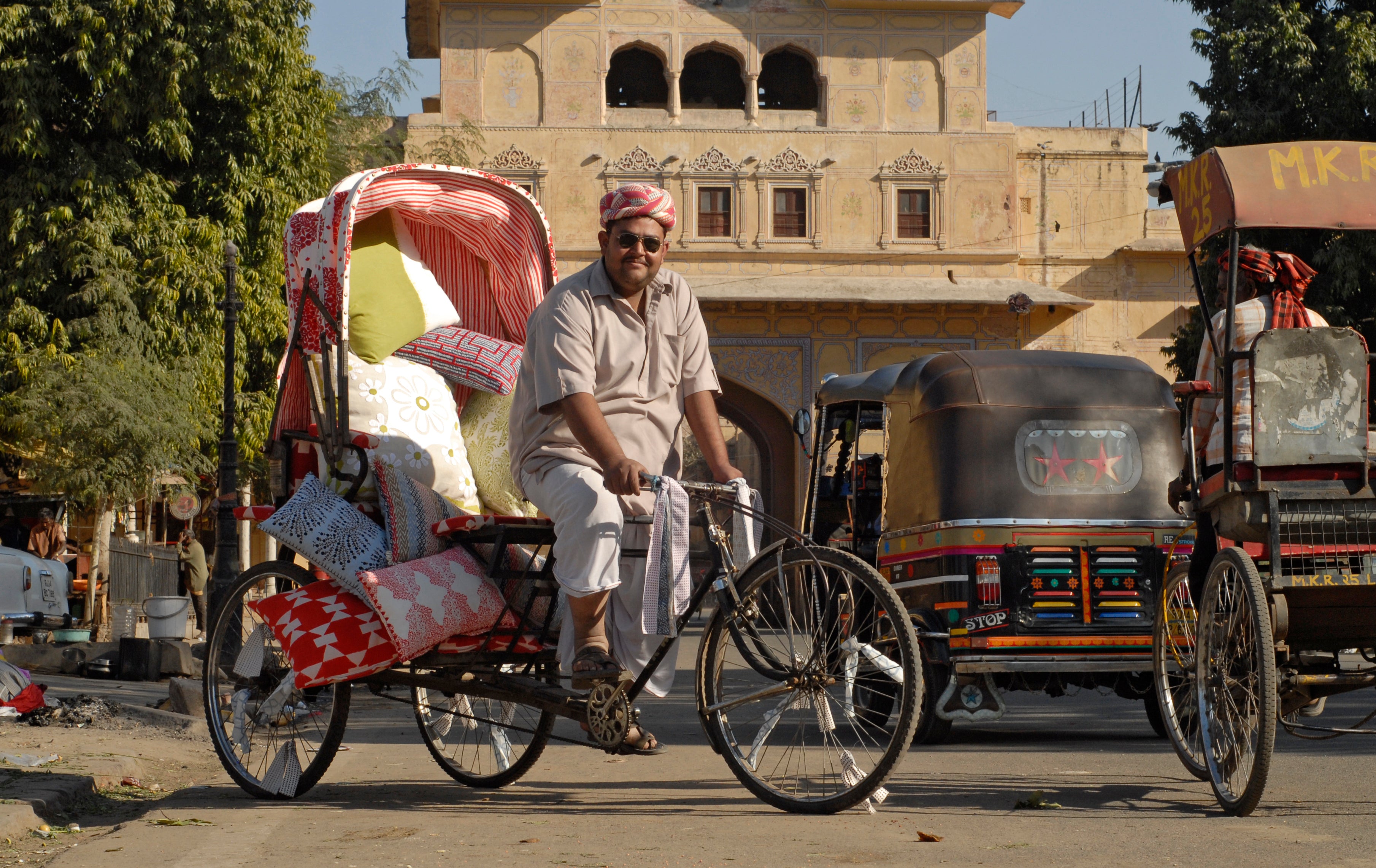 A rickshaw driver carries a load of textiles. Photo by Jonas Spinoy.