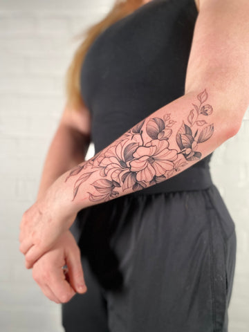 floral arm tattoo by female artist Lu Loram Martin, in Toronto, Canada.