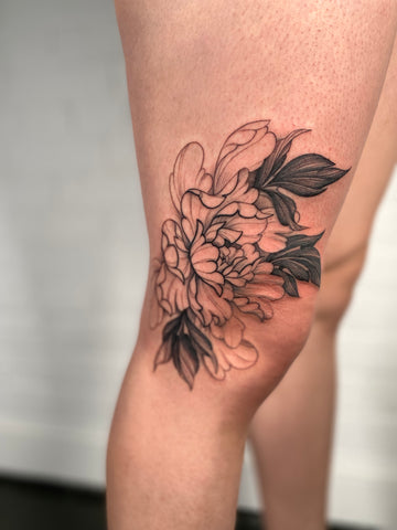 Floral knee tattoo by artist Lu Loram Martin, in Toronto, Canada.