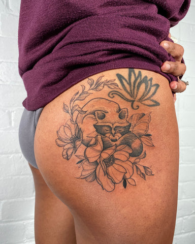 Floral raccoon tattoo by Lu Loram Martin, in Toronto, Canada.