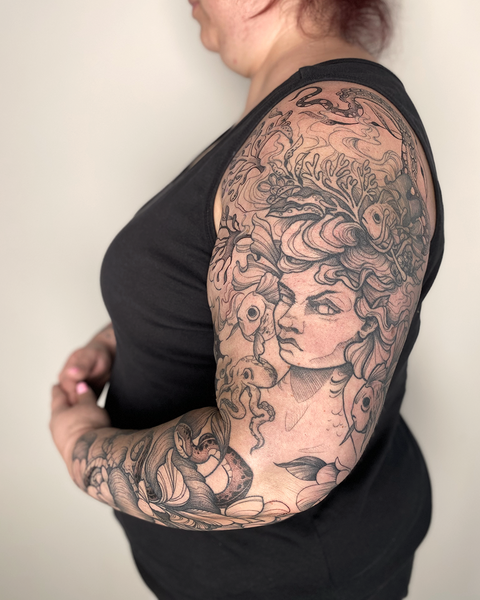 Beautiful feminine floral tattoo sleeve on larger woman, with sea urchin, by floral tattoo artist, Lu Loram-Martin, in Toronto, Canada