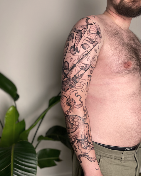 Beautiful male sleeve blackwork floral tattoo with octopus, ship and swallow birds,by floral tattoo artist, Lu Loram-Martin, in Toronto, Canada