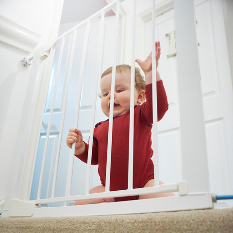 bébé derrière la barrière de l'escalier