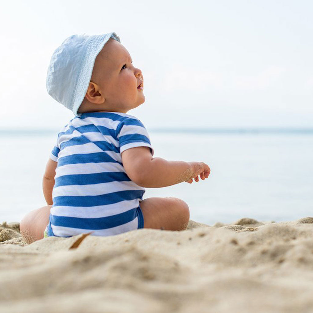 baby boy smiling sitting up unassisted without support on beach