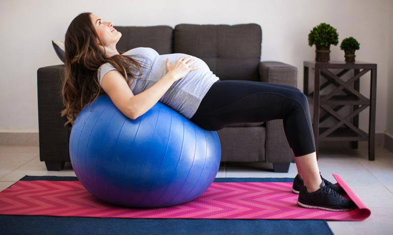 Pregnant Woman Lying Back on Birthing Ball in Small Bridge Position at Home