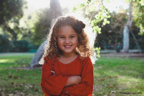 girl with curly hair and bow