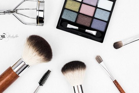 An eyeshadow pallet and makeup brushes pictured on a white surface | ML Delicate Beauty