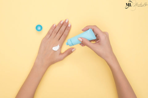 A woman using a hand moisturizer cream | ML Delicate Beauty