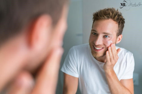 Man applying moisturizer in the bathroom mirror - ML Delicate Beauty