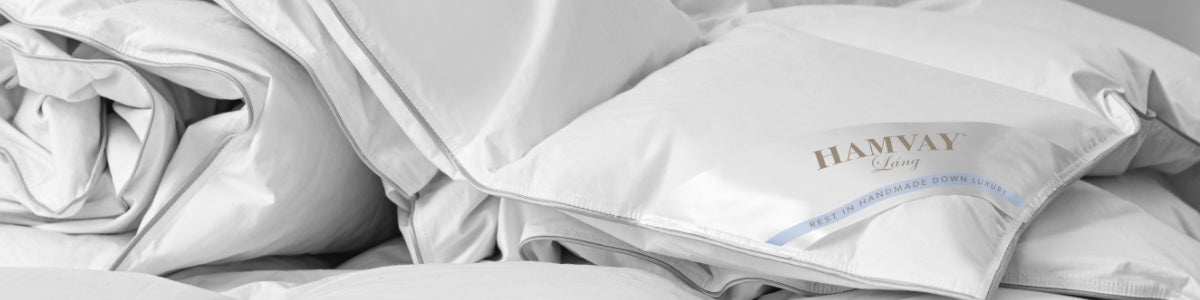 detail of white down comforter folded on bed