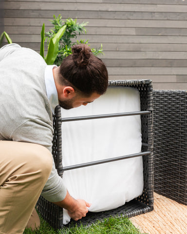 A man fixing a piece of wicker furniture