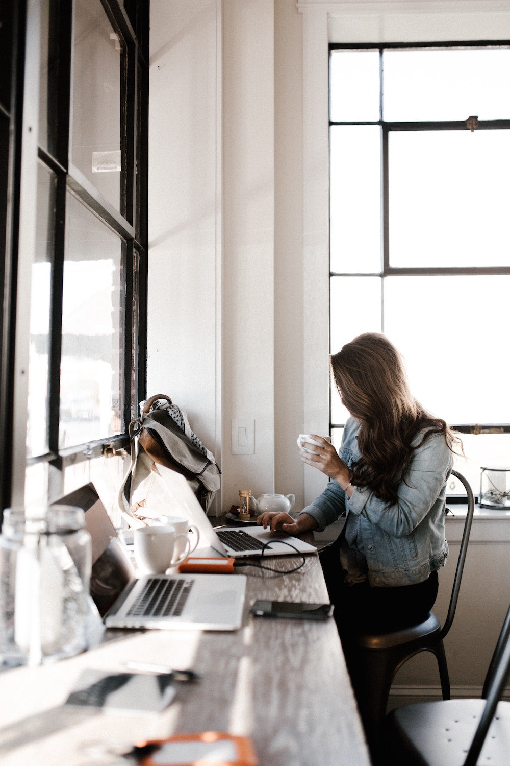 People working on laptops at a modern work table.