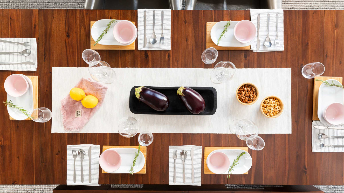 An extendable dining table from above that is set for a meal.