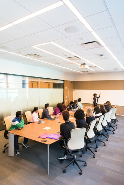 A group of people sitting inside a conference room to share ideas and presentation