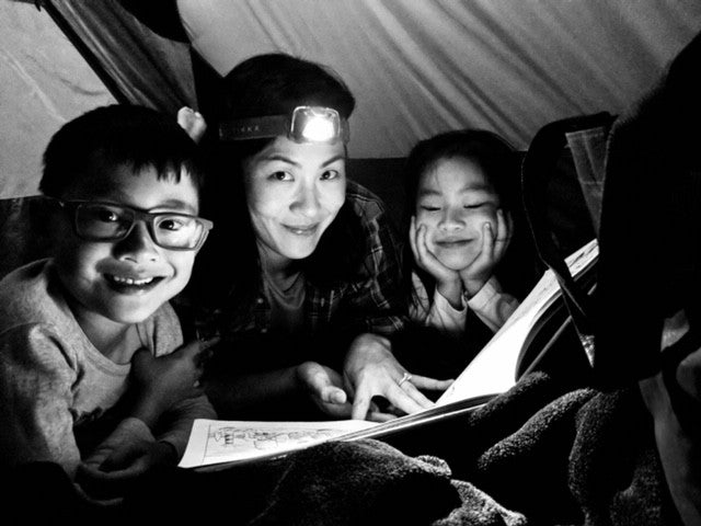 Tien reading to her kids on a recent camping trip.