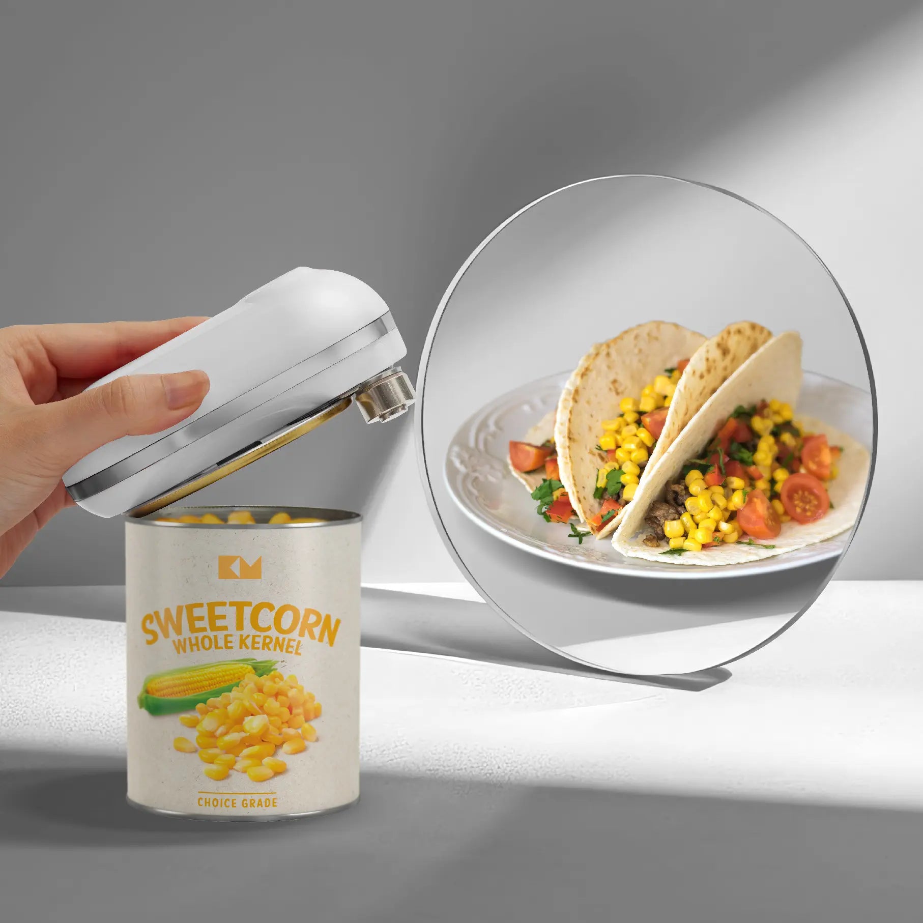 A hand holds a can opener above a can of sweetcorn, with a mirror showing tacos filled with corn, tomatoes, and greens.