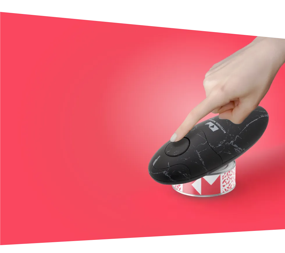 Hand presses black marble Kitchen Mama can opener on a can, red background with white framing highlights sleek design.