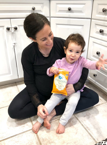 Woman with daughter eating Puffworks baby peanut butter puffs