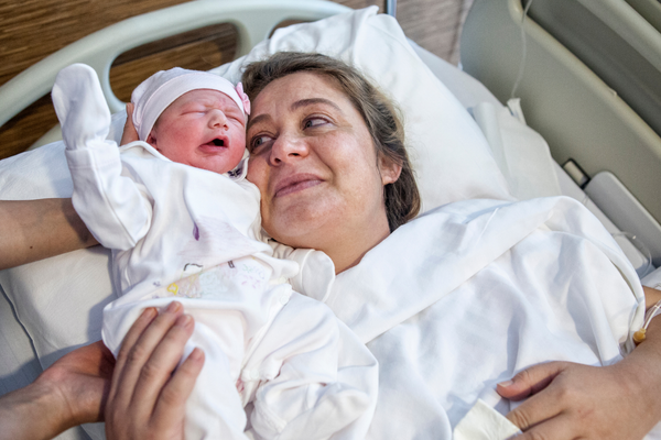 A mother holding her precious newborn baby in a hospital bed after childbirth