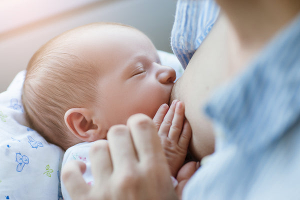 A mother breastfeeding her newborn with a proper latch