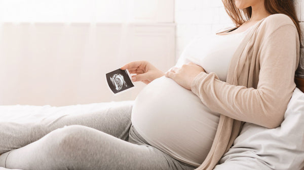 Raskaana oleva nainen katsoo kuvaa ultraäänestään
