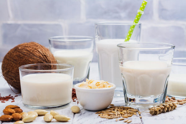 A spread of coconut, almonds, and glasses of milk