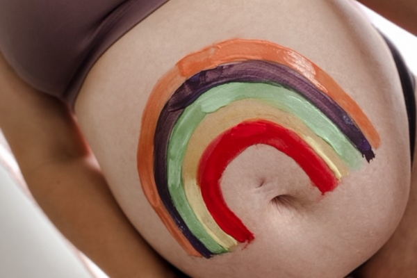 Pregnancy stomach with painted rainbow on it