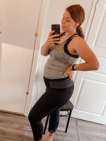 A pregnant woman, Jenna, taking a mirror selfie wearing her Lola&Lykke Core Relief pregnancy support belt