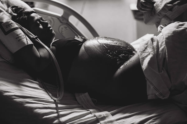 A pregnant woman laying in a hospital bed getting ready to have a C-section