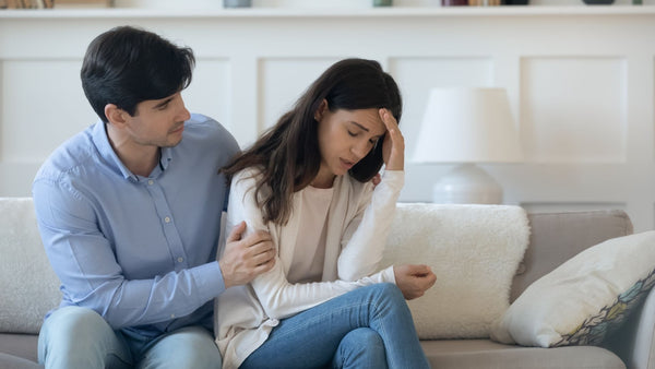 Man comforting gently his partner about struggles with infertility in bright living room