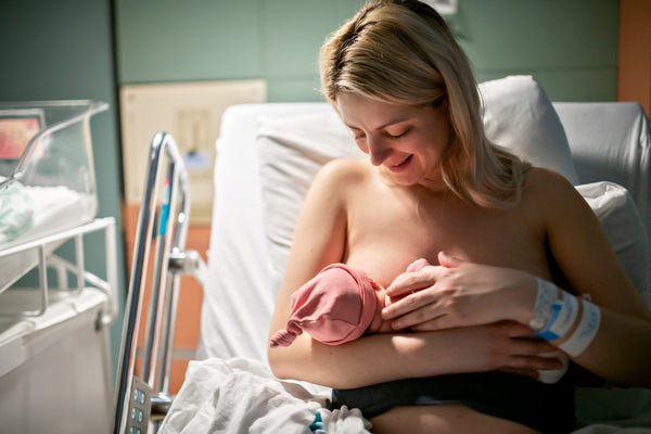 Woman breastfeeds a newborn baby