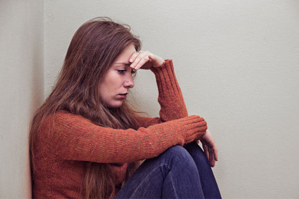 A woman in red long-sleeved sweater feeling sad pregnancy loss