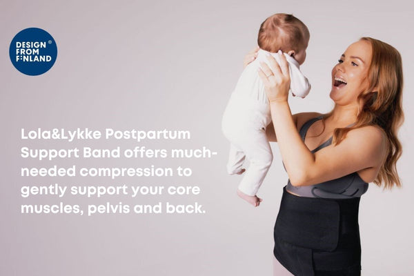 Happy mother holding her baby while wearing Lola&Lykke Postpartum Support Band