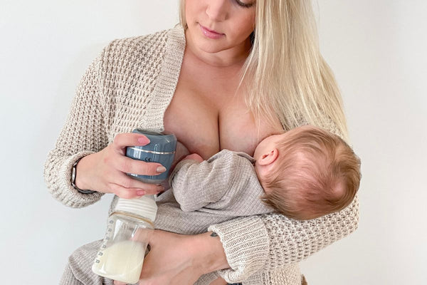 woman breastfeeding her newborn baby while simultaneously pumping with a wireless electric breast pump