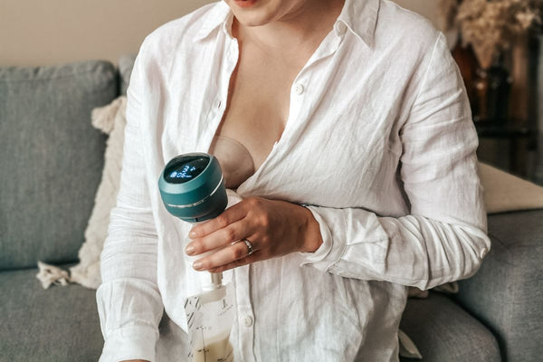mom is pumping breast milk after breastfeeding her baby in a calm room